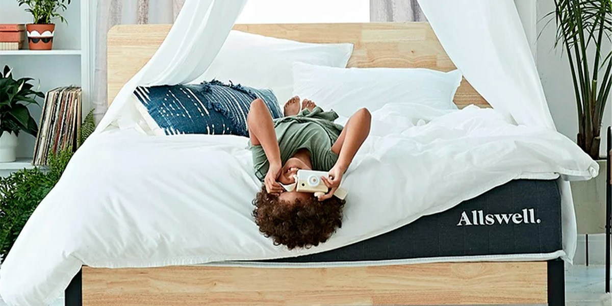 Person laying on bed looking through camera lens