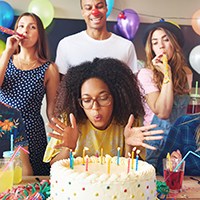 a woman blowing the birthday candles