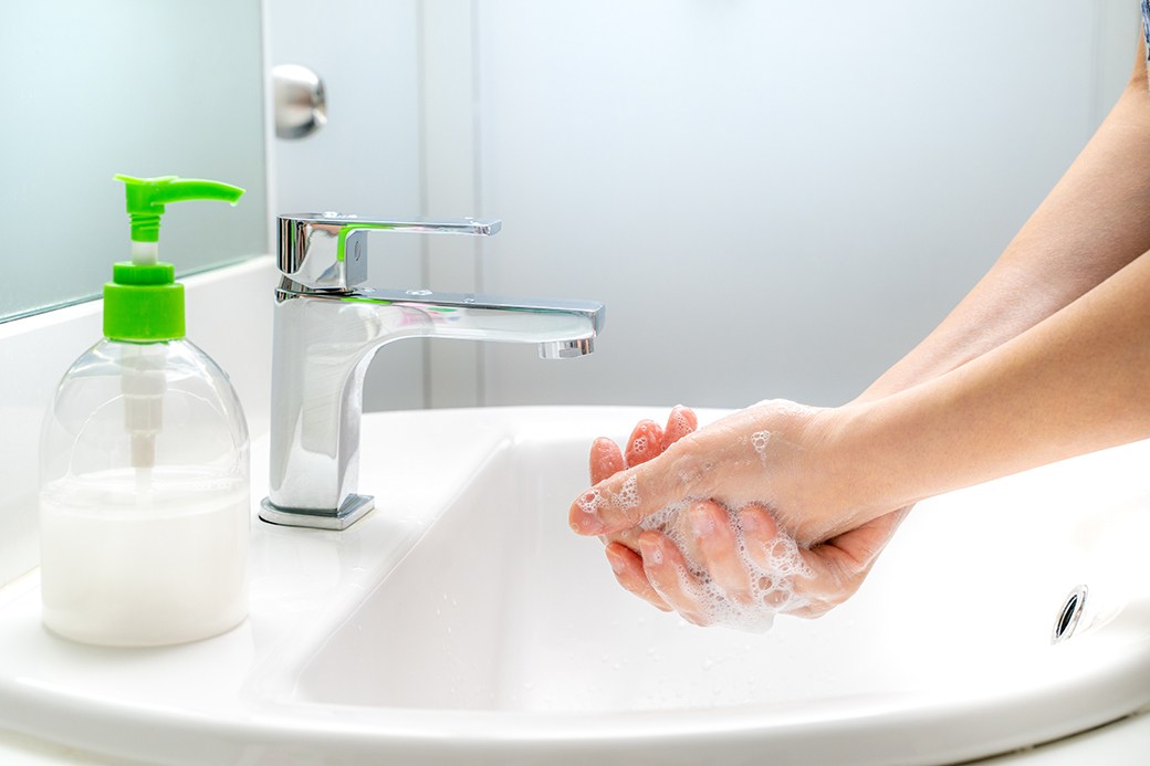 Person washing hands with soap